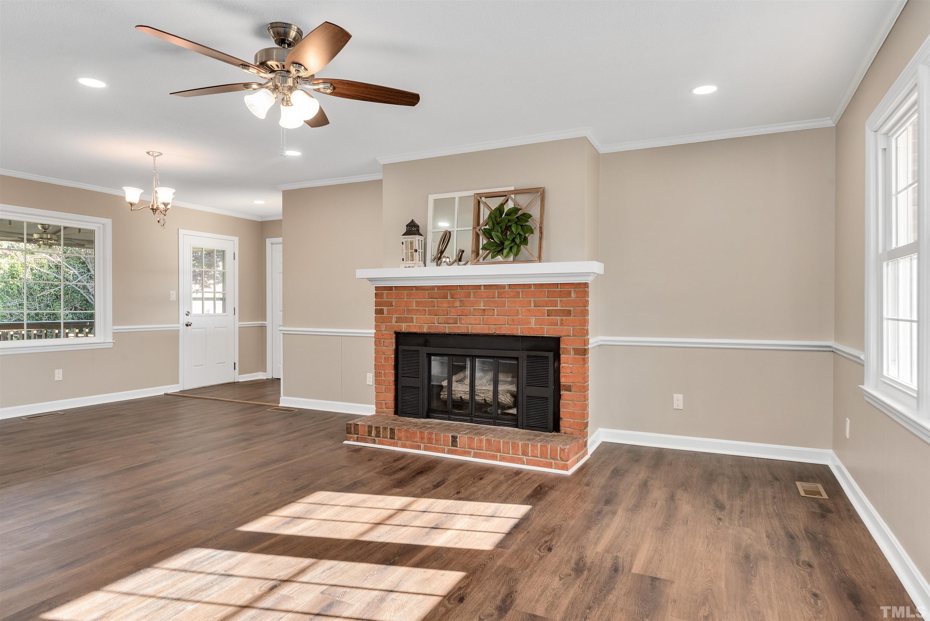 5630 Fairground Road Dunn, NC 28334 - Photo 3 of 33 a view of a livingroom with a fireplace a ceiling fan and wooden floor