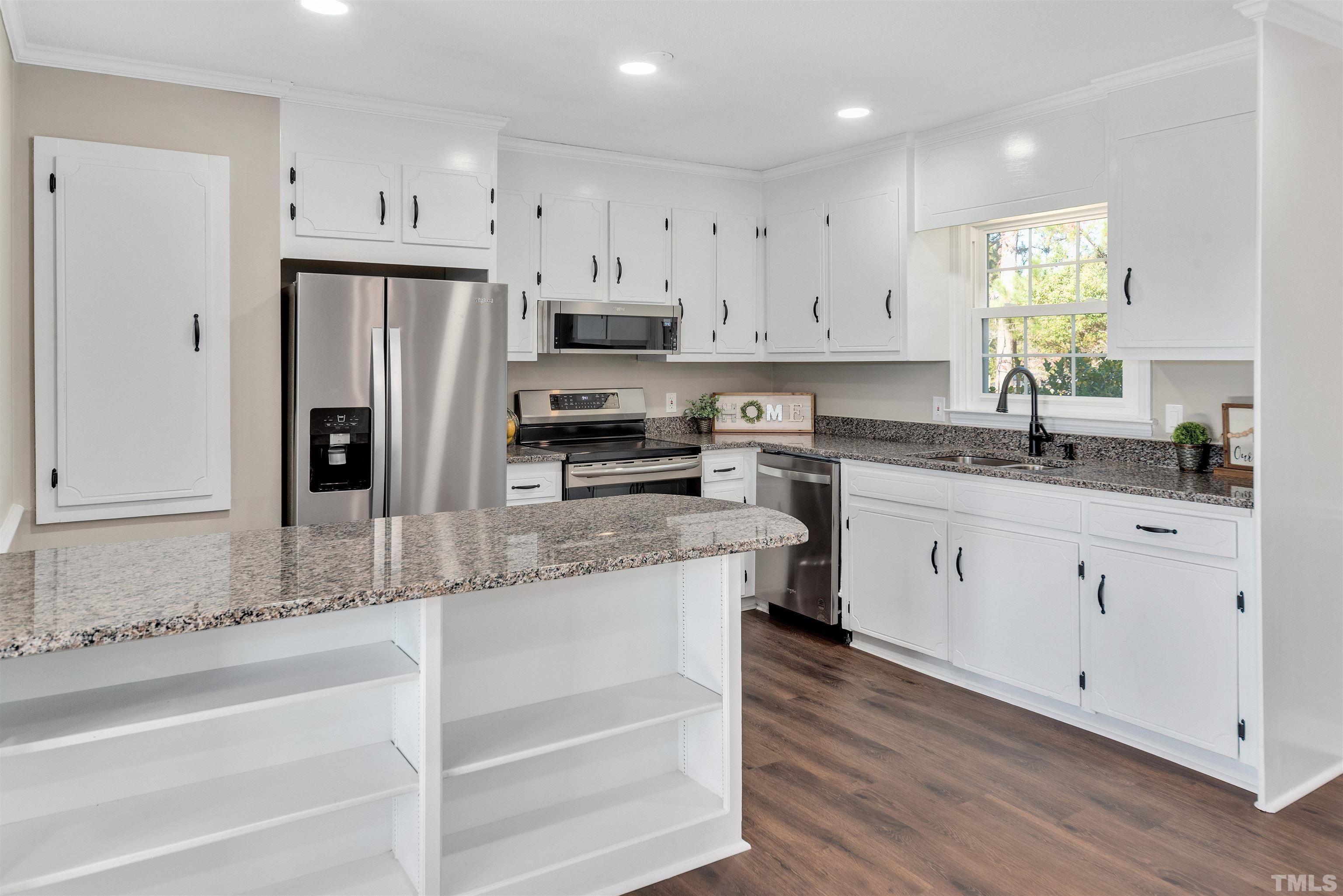 5630 Fairground Road Dunn, NC 28334 - Photo 10 of 33 a kitchen with stainless steel appliances granite countertop a refrigerator a sink dishwasher a stove and white cabinets with wooden floor