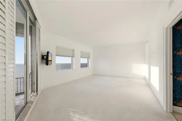 a large white kitchen with a large window and chandelier
