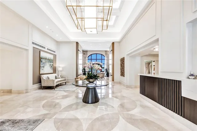 a view of a livingroom with furniture a flat screen tv and windows