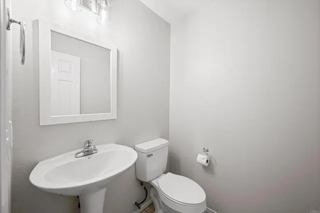 a bathroom with a sink a toilet and mirror