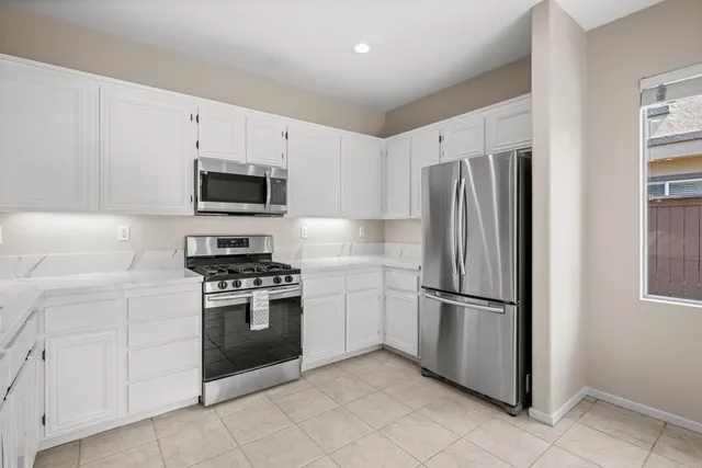 a kitchen with cabinets stainless steel appliances and a window