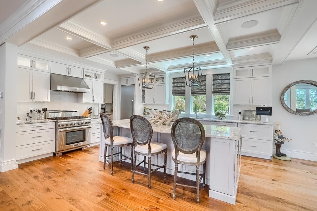 170 Otis Street Hingham, MA 02043 - Photo 12 of 24 a kitchen with stainless steel appliances a stove a sink dishwasher a dining table and chair with wooden floor