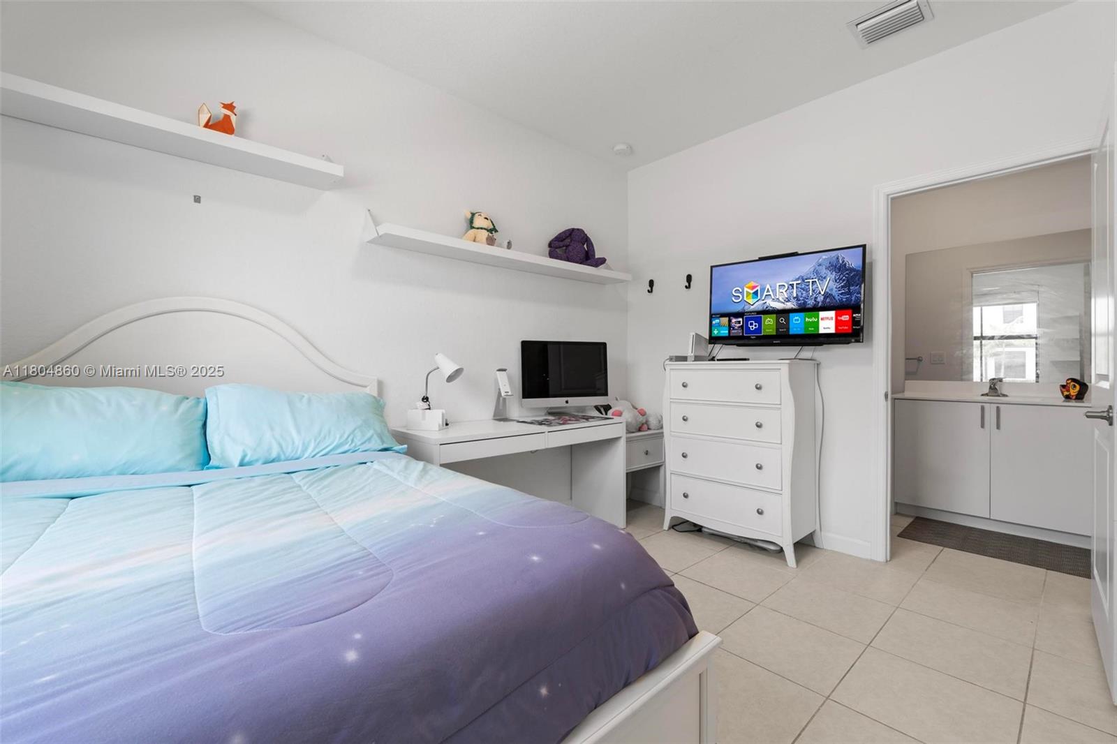 23517 Southwest 127th Place Homestead, FL 33032 - Photo 3 of 28 a bedroom with a bed and a television