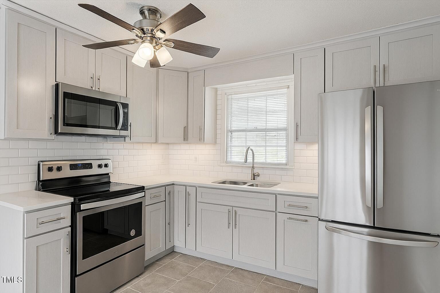 1813 Grady Drive Durham, NC 27712 - Photo 2 of 32 a kitchen with cabinets stainless steel appliances and a window