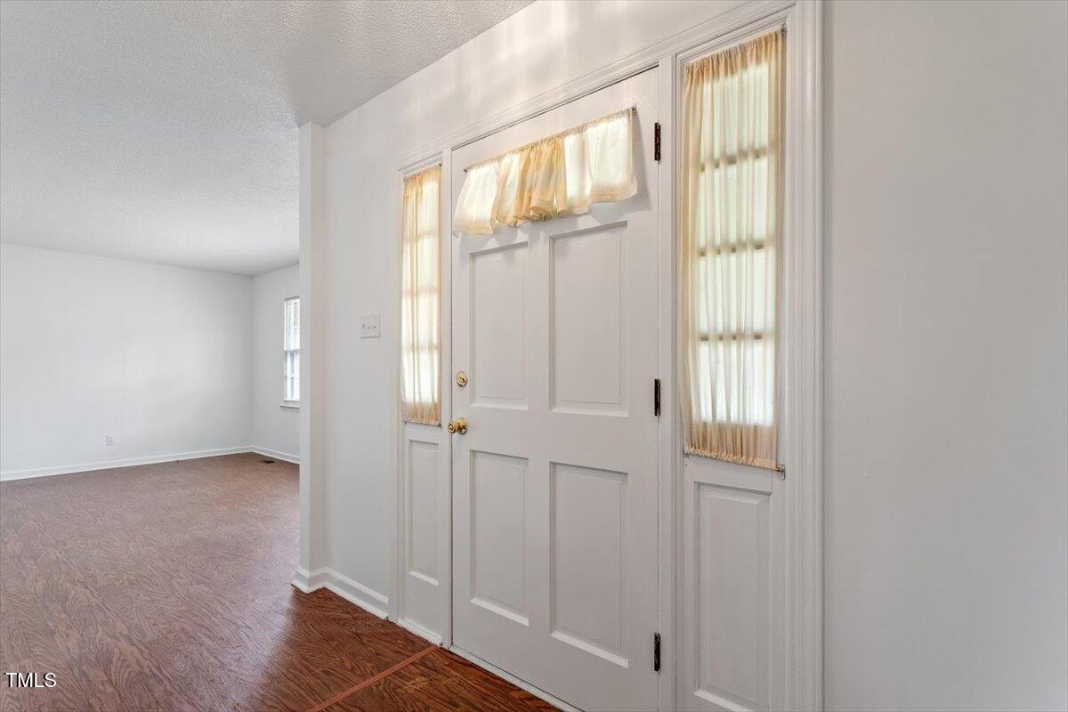 1813 Grady Drive Durham, NC 27712 - Photo 23 of 32 a view of an empty room with wooden floor and a window