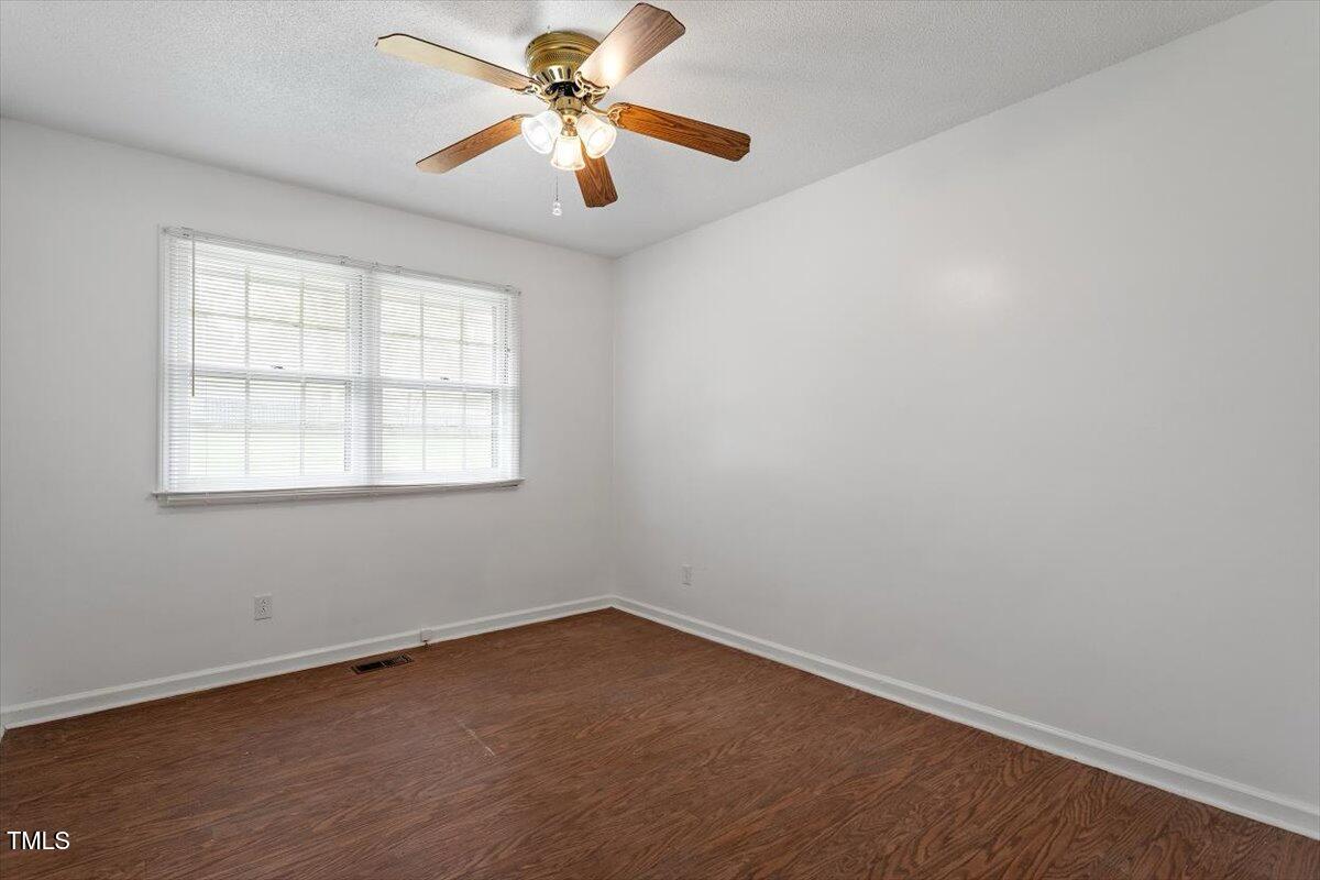 1813 Grady Drive Durham, NC 27712 - Photo 9 of 32 an empty room with a window and a fan