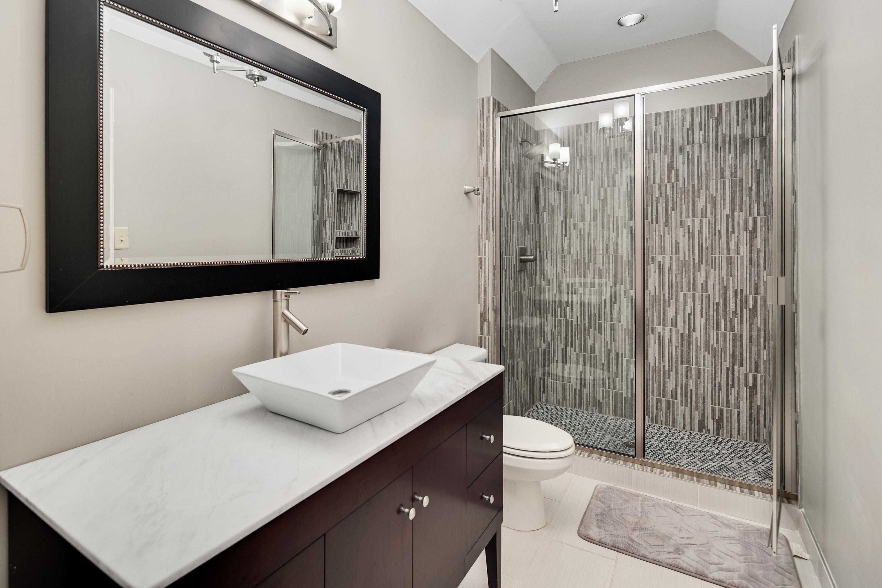 415 South Yates Road Memphis, TN 38120 - Photo 27 of 30 a bathroom with a sink a toilet a mirror and shower