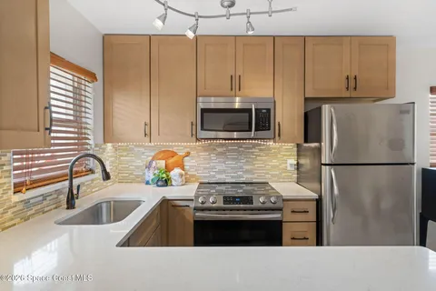 a kitchen with stainless steel appliances a refrigerator sink and stove