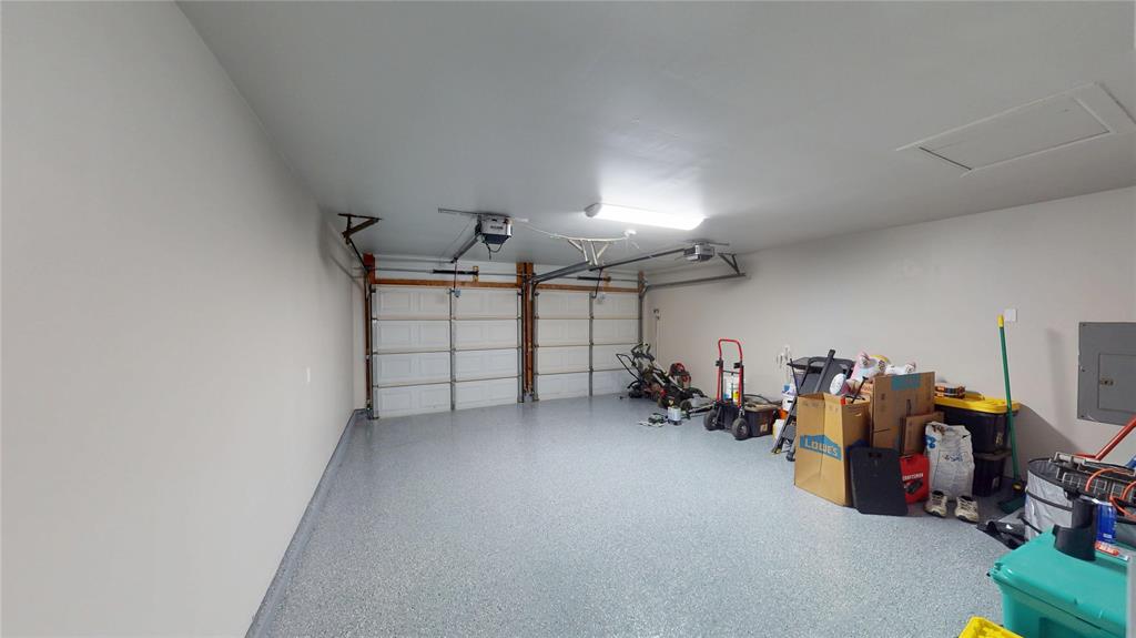 1317 Colonial Place Flower Mound, TX 75028 - Photo 16 of 20 Spacious garage featuring a durable flake epoxy flooring, two overhead garage doors, automatic garage door openers, and recessed lighting