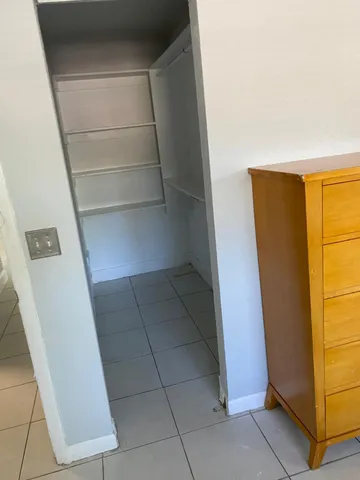 a view of walk in closet with empty racks