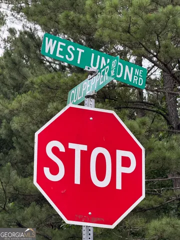 a view of outdoor space with a street sign and a forest view