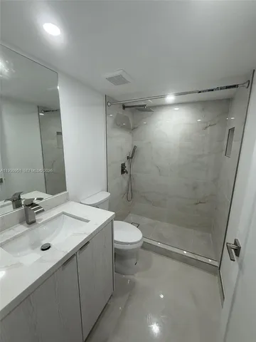 a large white kitchen with sink and a large mirror