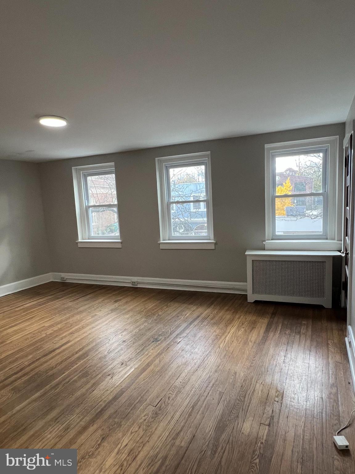 243 Haverford Avenue, Unit 2 Narberth, PA 19072 - Photo 2 of 10 a view of an empty room with wooden floor and a window