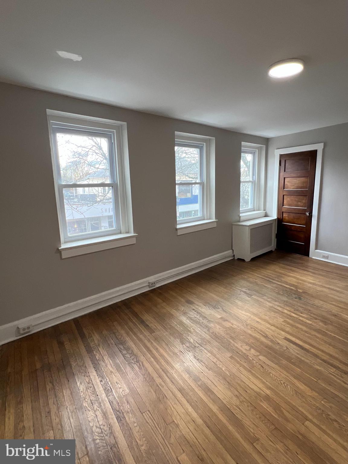 243 Haverford Avenue, Unit 2 Narberth, PA 19072 - Photo 4 of 10 a view of an empty room with wooden floor and a window