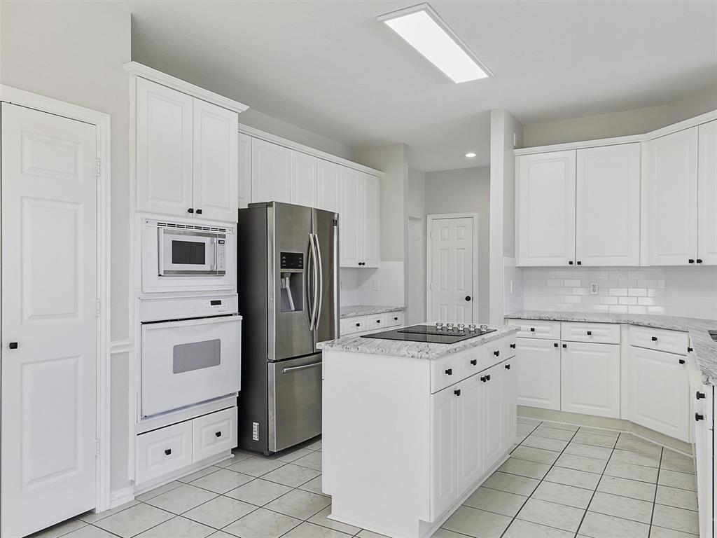 7612 Pendleton Street Dallas, TX 75252 - Photo 17 of 38 a kitchen with white cabinets and stainless steel appliances