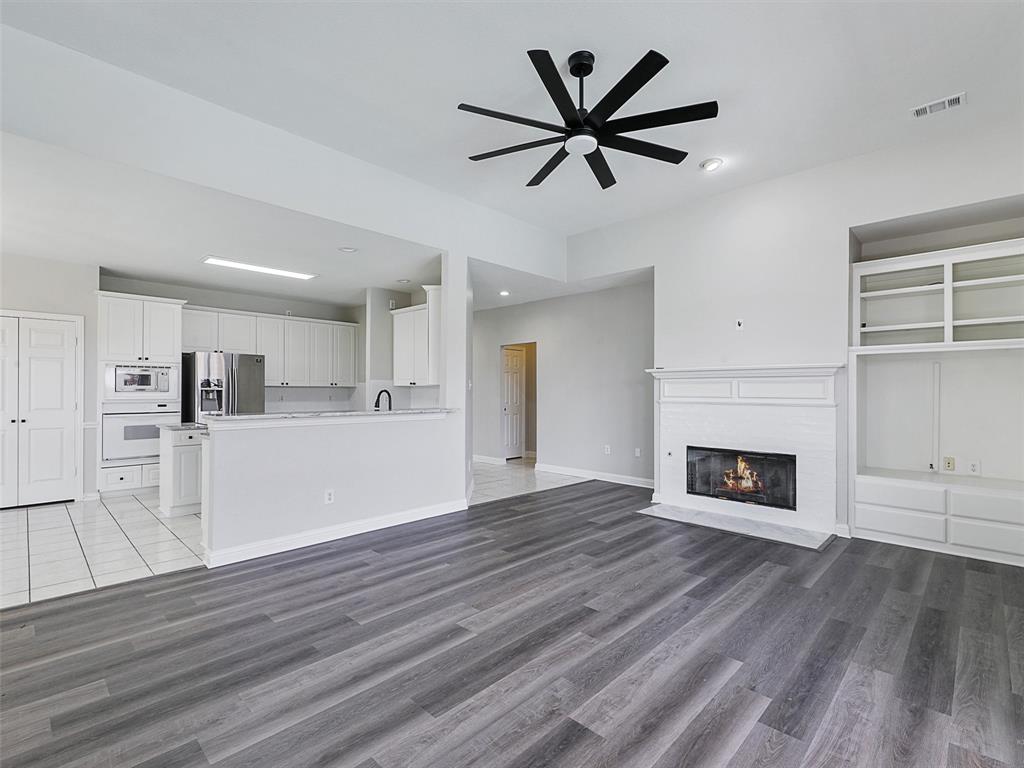 7612 Pendleton Street Dallas, TX 75252 - Photo 20 of 38 a view of a livingroom with a fireplace a ceiling fan and wooden floor