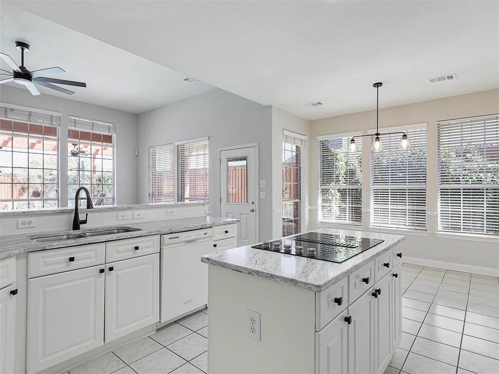 7612 Pendleton Street Dallas, TX 75252 - Photo 3 of 38 a kitchen with granite countertop a sink and white cabinets
