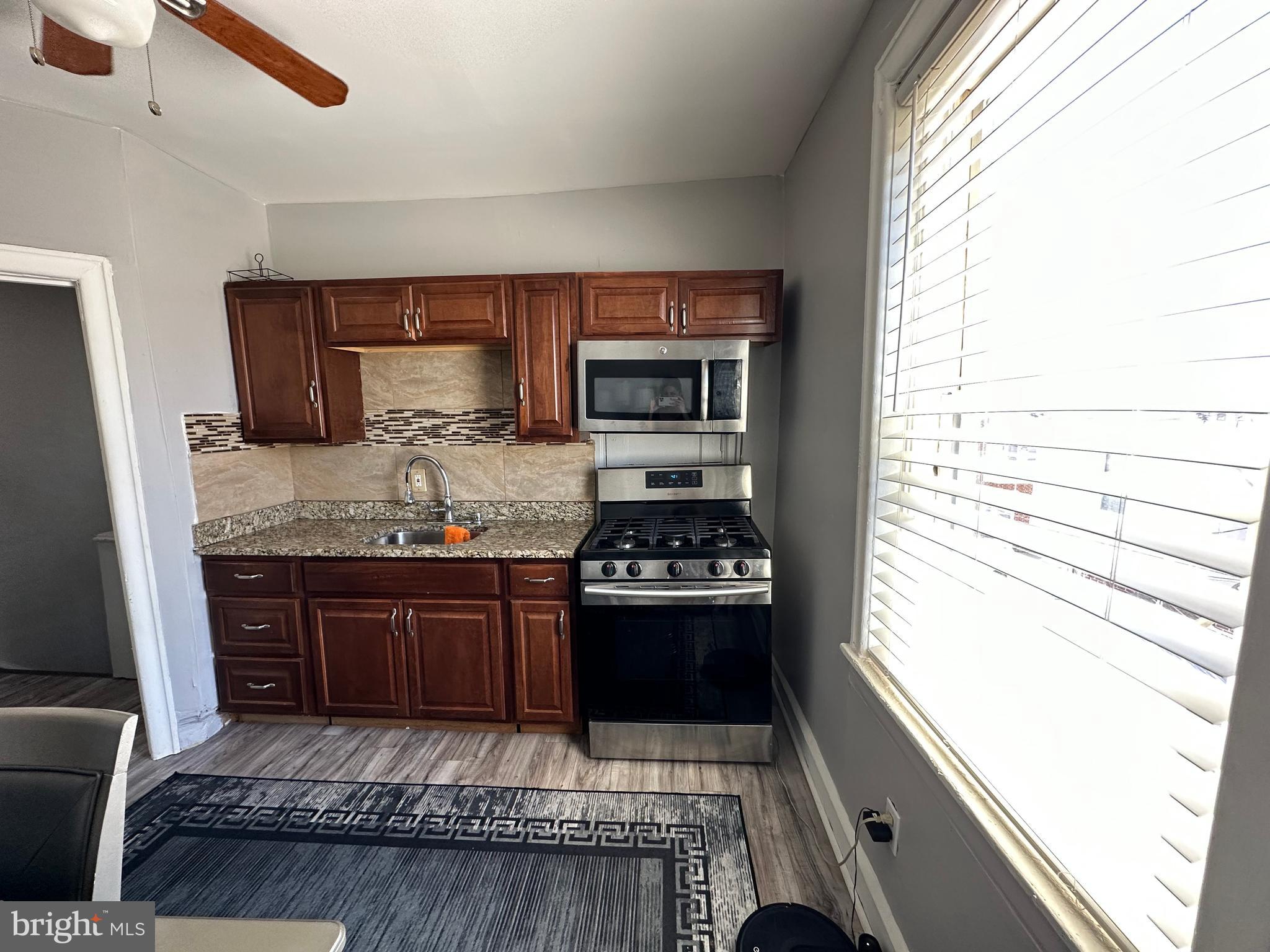 4914 Ormes Street Philadelphia, PA 19120 - Photo 28 of 33 a kitchen with granite countertop stainless steel appliances a stove a sink and a refrigerator
