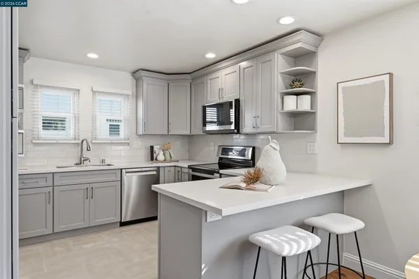 a kitchen that has a sink a table and chairs in it