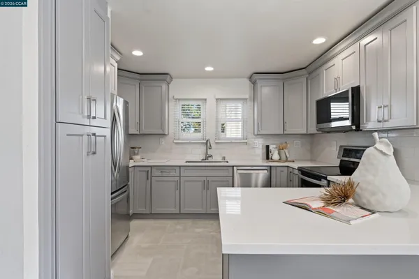 a kitchen with stainless steel appliances granite countertop a refrigerator and a stove top oven