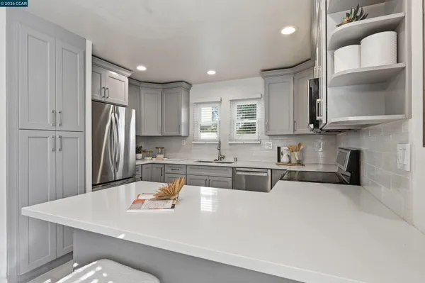 a kitchen with kitchen island a sink a stove a refrigerator and cabinets