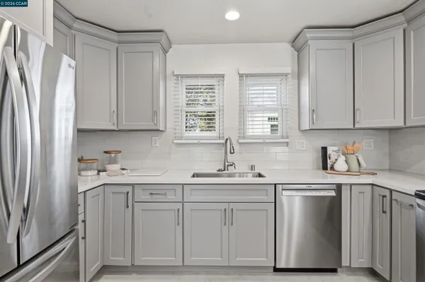 a kitchen with cabinets appliances a sink and a window