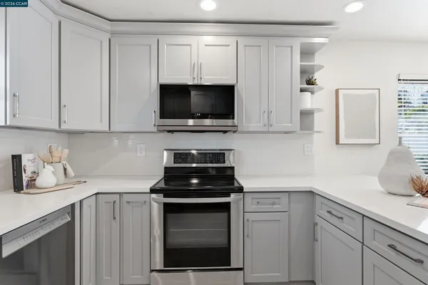 a kitchen with white cabinets and black appliances