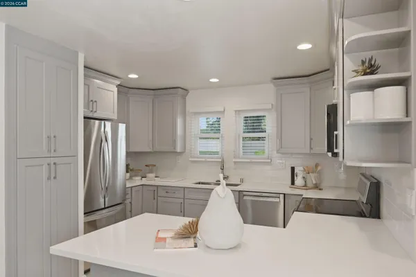 a view of an empty room with wooden floor and windows