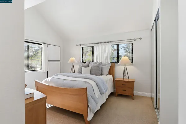 a bedroom with a bed a mirror and a large window