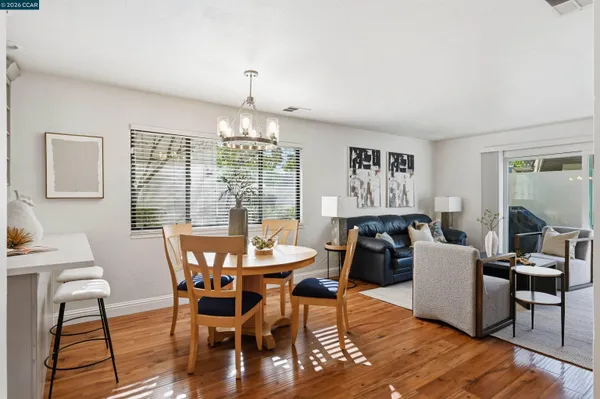 a dining room with furniture a chandelier and wooden floor