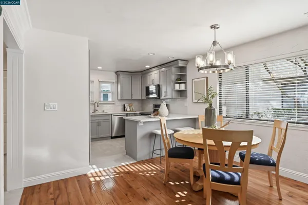 a view of a dining room with furniture a chandelier and wooden floor