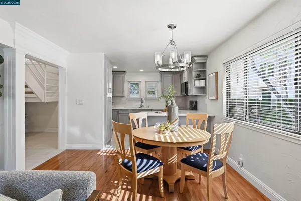 a dining room with furniture a chandelier and wooden floor