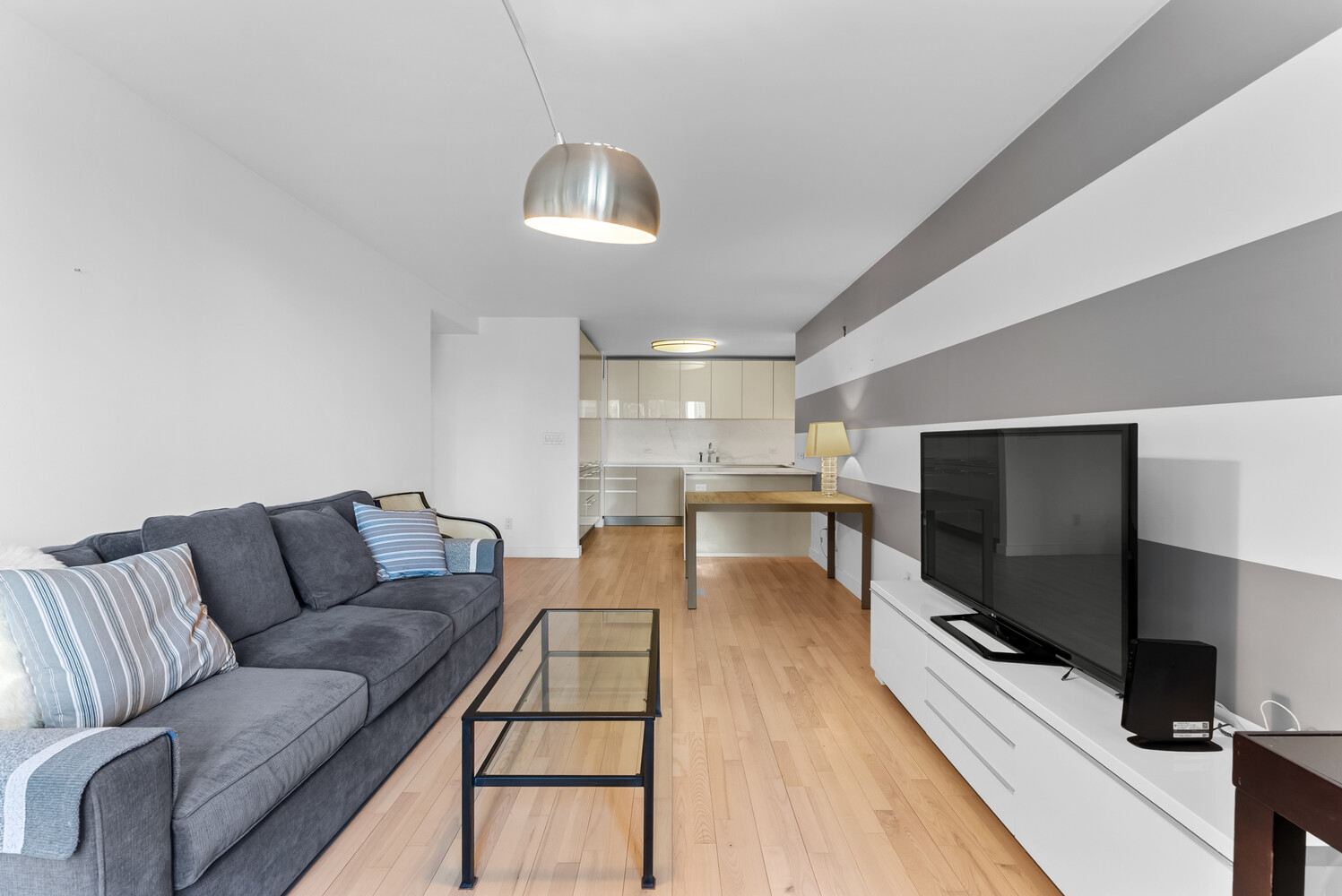 322 West 57th Street, Unit 39K Manhattan, NY 10019 - Photo 19 of 23 a living room with furniture and a flat screen tv