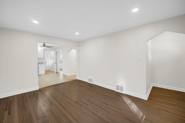 a view of empty room with wooden floor