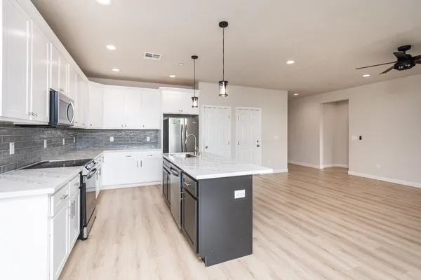a kitchen with kitchen island a sink appliances and cabinets