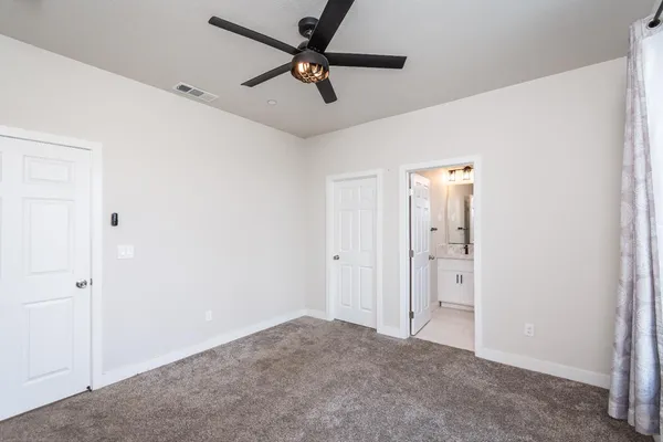 a view of a livingroom with a ceiling fan & cabinetry