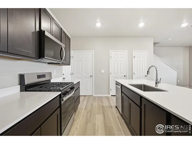 a kitchen with a sink stove top oven and refrigerator