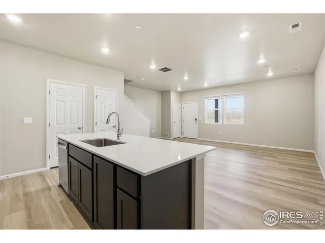 a kitchen with a sink a window and wooden cabinets
