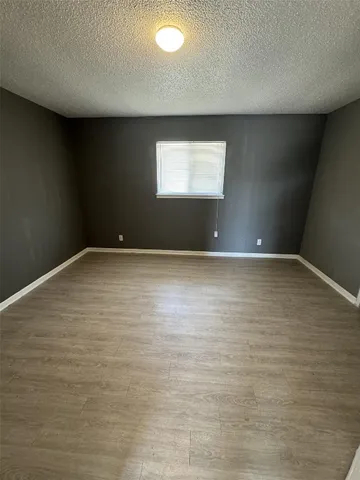an empty room with wooden floor and entrance