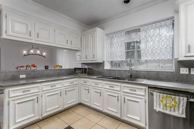 a kitchen with granite countertop white cabinets white appliances and a sink