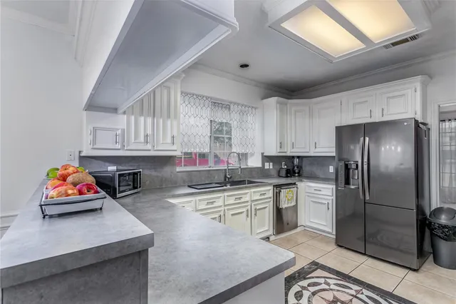 a kitchen with stainless steel appliances granite countertop a sink refrigerator and cabinets