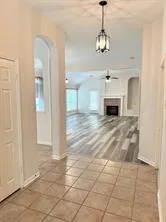 a view of a livingroom with a chandelier a fireplace a windows and a chandelier