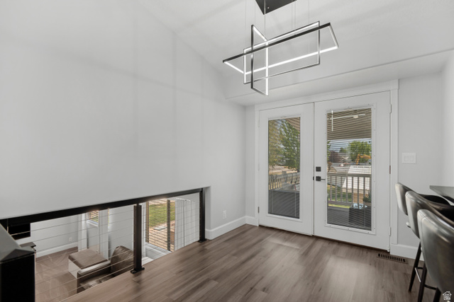 4752 South 4075th Street West Roy, UT 84067 - Photo 5 of 28 Open-concept space featuring a modern linear chandelier, wood-finish flooring, and white double French doors
