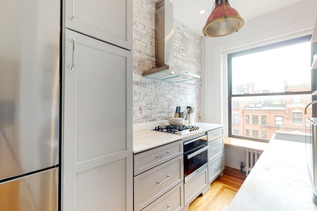 405 Marlborough Street, Unit 41 Boston, MA 02115 - Photo 13 of 32 a kitchen with stainless steel appliances a stove a refrigerator and a window