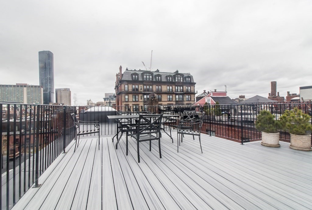 405 Marlborough Street, Unit 41 Boston, MA 02115 - Photo 24 of 32 a view of a rooftop deck with chairs and wooden floor