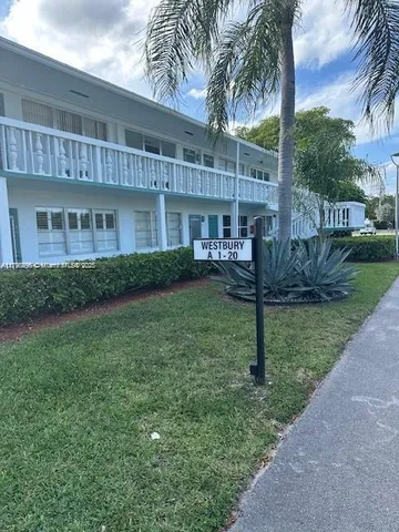 a view of a house with a yard and potted plants