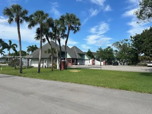 a view of a park with a house in background