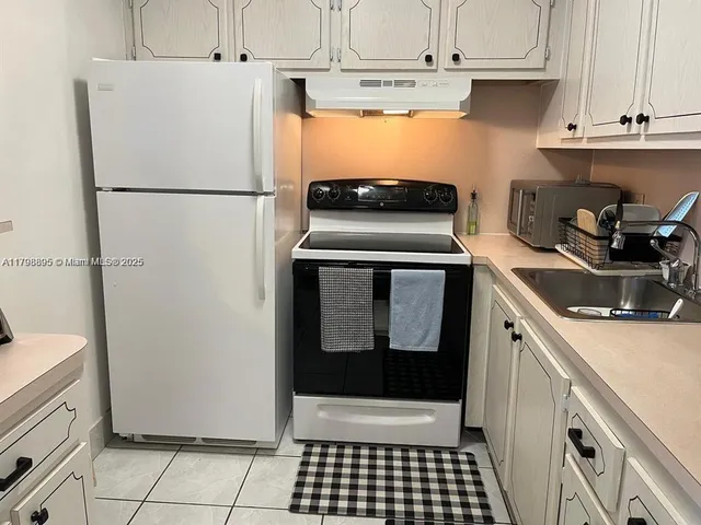 a kitchen with a refrigerator and a sink