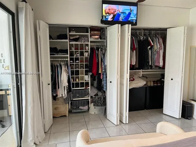 a view of walk in closet with clothes and shoes